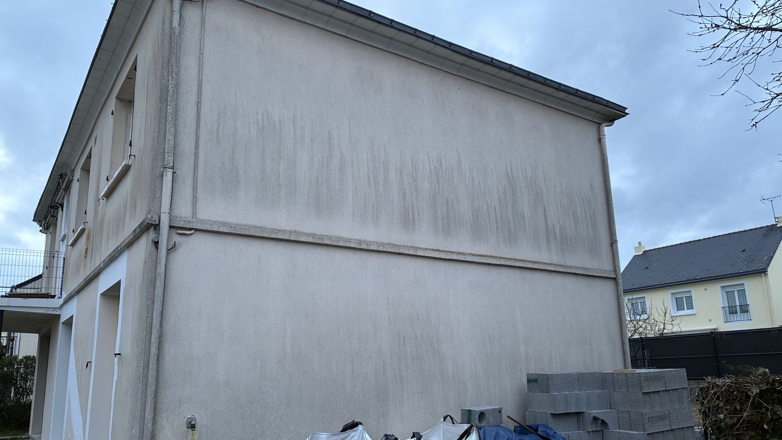 Pignon couvert de coulures vertes sur toute sa hauteur avant ravalement par Armel Entreprise