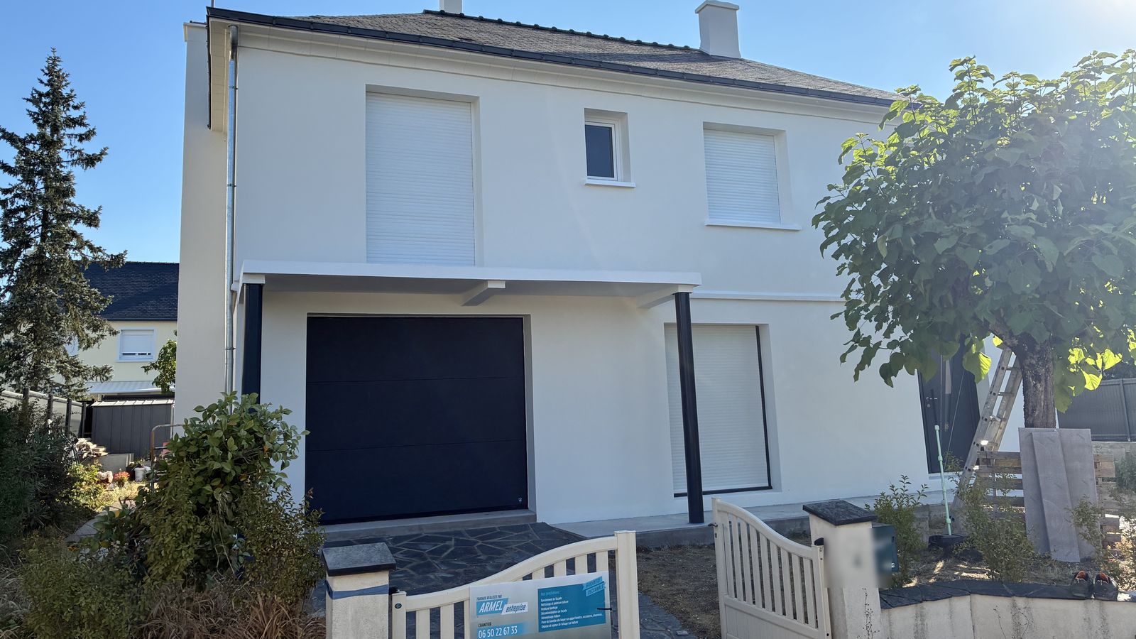 Panneau de chantier d'Armel Entreprise devant un pavillon dont la façade vient d'être ravalée