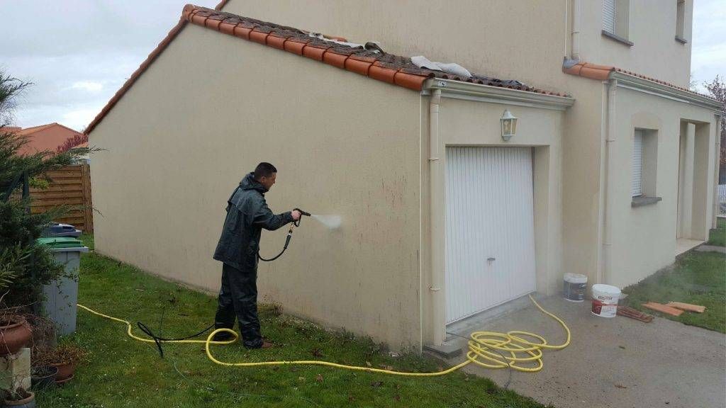 Compagnon d'Armel Entreprise nettoyant une façade au nettoyeur haute pression avant ravalement