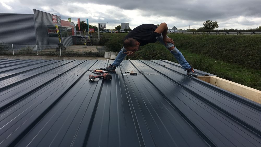 Pose d'une couverture en bac acier par un compagnon d'Armel Entreprise